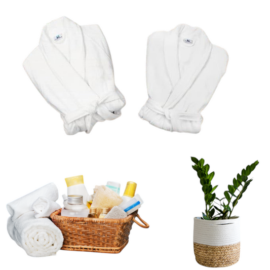 Two white nkhandcraftedgifts custom bathrobes with spa accessories in a basket and a potted plant
