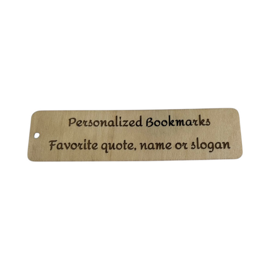 nkhandcraftedgifts personalized birch wood bookmark with engraved text resting on a rustic wooden slice surface